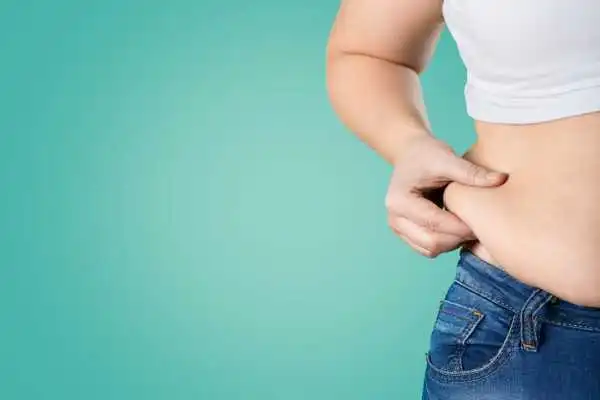 Image of woman pinching her love handles to show weight gain Lyndhurst